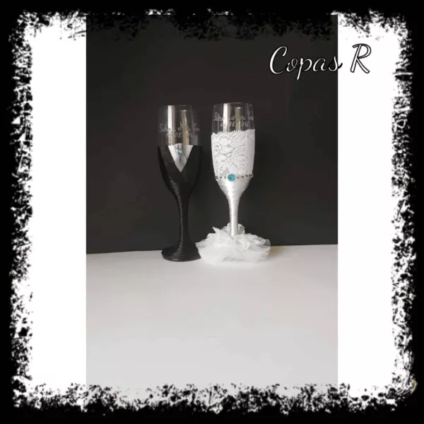 Copas de novios personalizadas en blanco y negro con encaje, pluma blanca y detalle azul