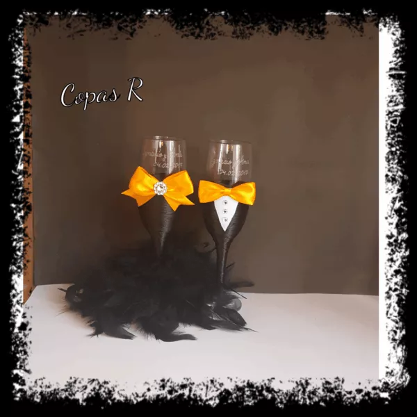 Copas de novios personalizadas en negro con pajarita y lazo naranja y plumas negras