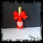 Botella de cava decorada roja con lazo y corazón de perlas blancas