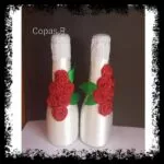 Pareja de botellas de cava decoradas en blanco con rosas rojas