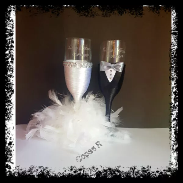 Copas de novios personalizadas en blanco y negro con plumas blancas, brillantes y esmoquin
