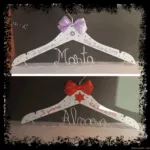 Perchas infantiles blancas con lazo y estrella, lila y roja