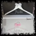 Perchas infantiles blancas con lazo blanco y lazo de tul rosa