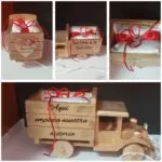 Camión de madera porta alianzas con lazo rojo Aquí empieza historia