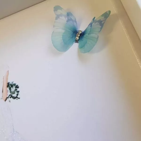 Cuadro personalizado decorado con mariposa de organza azul turquesa y strass sobre fondo blanco