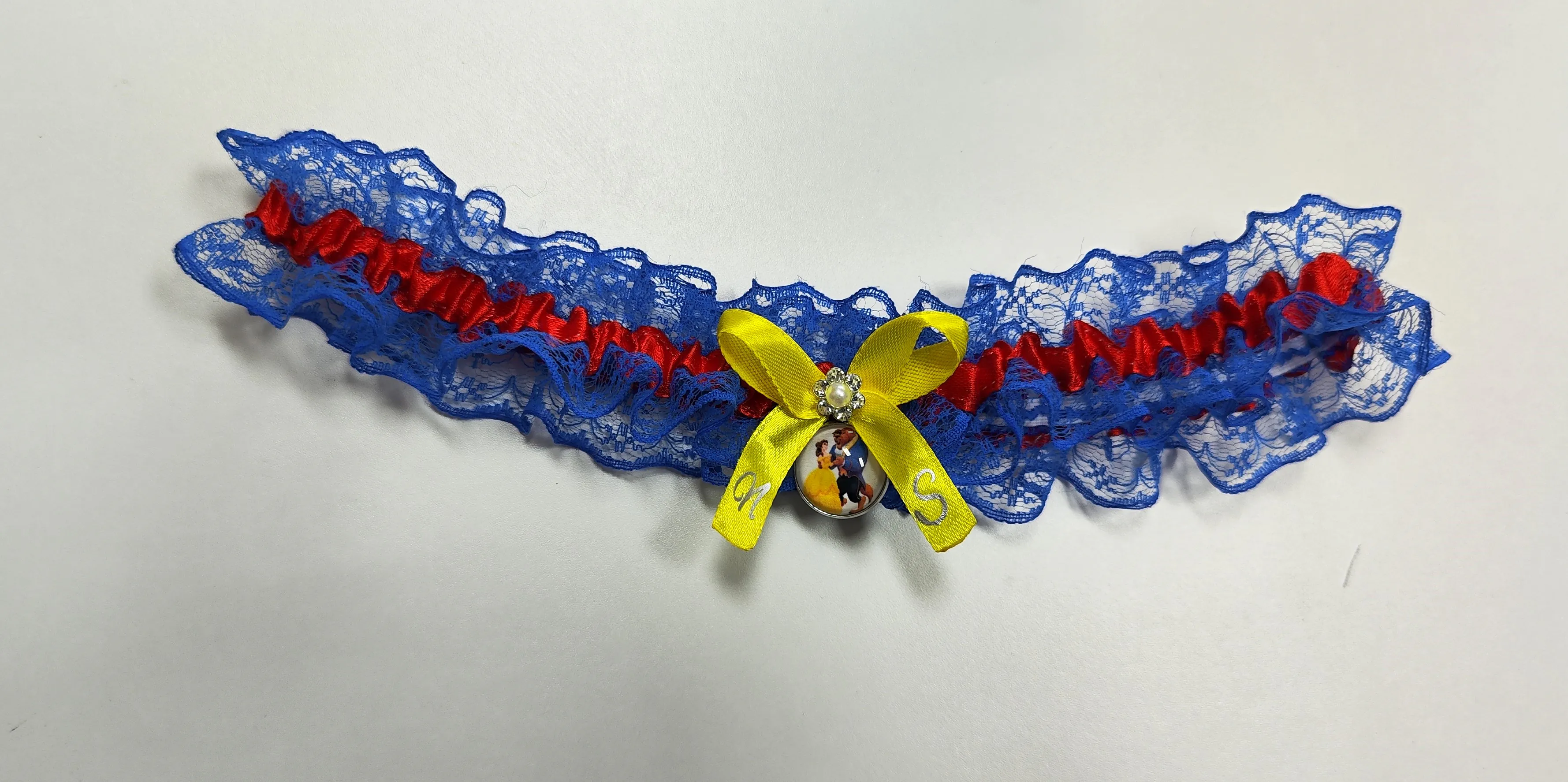 Liga personalizada en encaje azul con temática Bella y Bestia para bodas