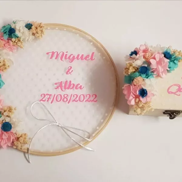 Bastidor porta alianzas de madera con flores de colores y caja de alianzas a juego con texto Sí Quiero
