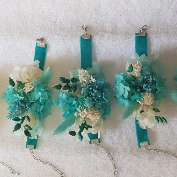 Hermosa pulsera de damas de honor con flores preservadas en tonos turquesas y blancos. Perfecta para aportar un toque fresco y sofisticado en el gran día.