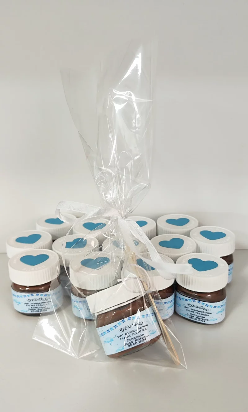 Mini Nutella personalizada con etiqueta azul y bolsita transparente con lazo blanco, ideal para comunión.