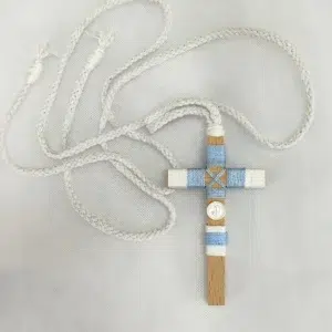 Cruz de comunión para niño en madera con hilo azul y blanco, inicial personalizada y cordón trenzado.