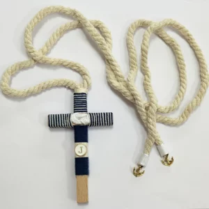 Cruz de comunión en madera con hilo azul marino y blanco a rayas, inicial personalizada y cordón trenzado con anclas doradas.