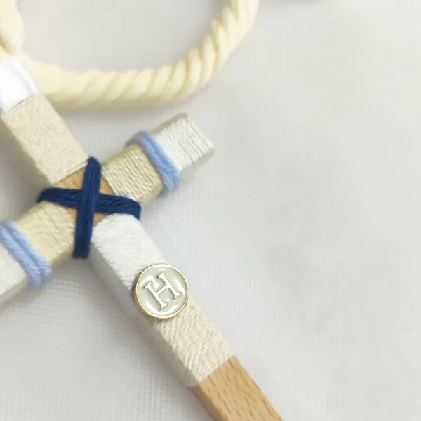 Cruz de comunión en madera con hilo beige, blanco y azul, inicial personalizada y cordón retorcido en color marfil.