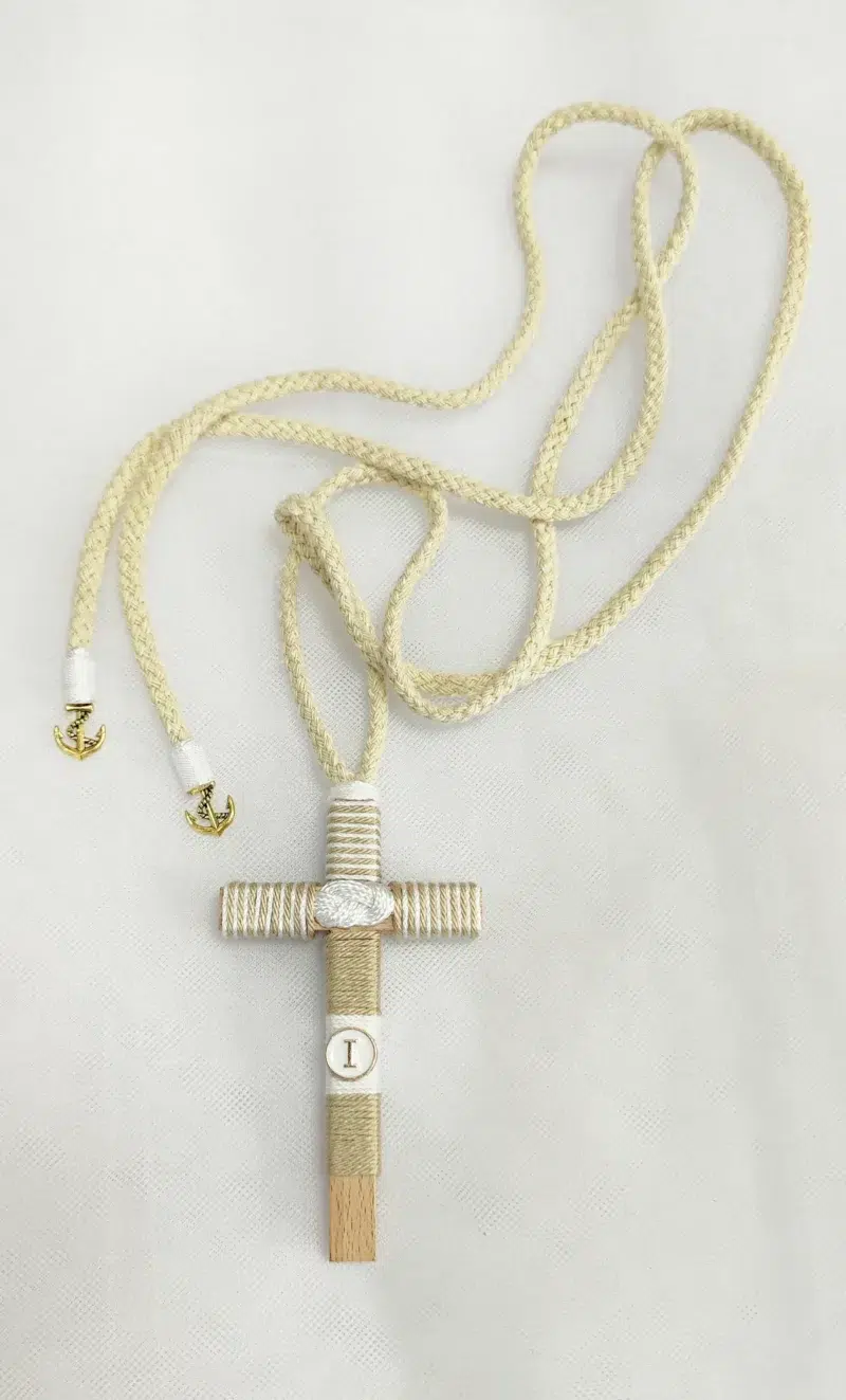 Cruz de comunión para niño en madera de 10 cm con inicial y cordón decorado con encaje y cinta.