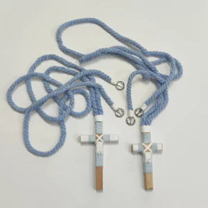 Conjunto de cruces de comunión en madera con hilo celeste y blanco, iniciales personalizadas y cordón trenzado azul con detalles plateados.