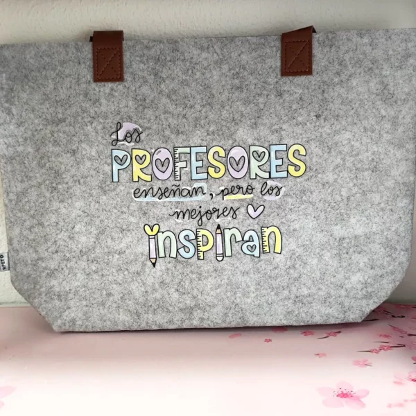 Bolso de fieltro gris para profesores con frase Los PROFESORES enseñan pero los mejores INSPIRAN y diseño colorido con lápices.