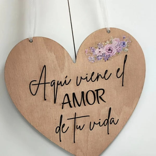 Cartel de madera con forma de corazón y cinta blanca, frase grabada “Aquí viene el amor de tu vida”, ideal para bodas