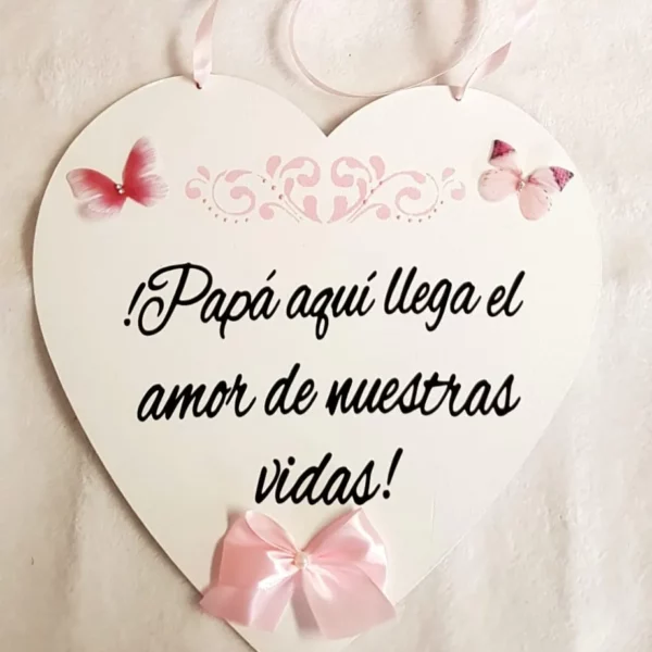 Cartel corazón de madera con cinta rosa y frase Papá aquí llega el amor de nuestras vidas para boda