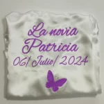 Bata satén blanca La novia con texto morado y mariposa