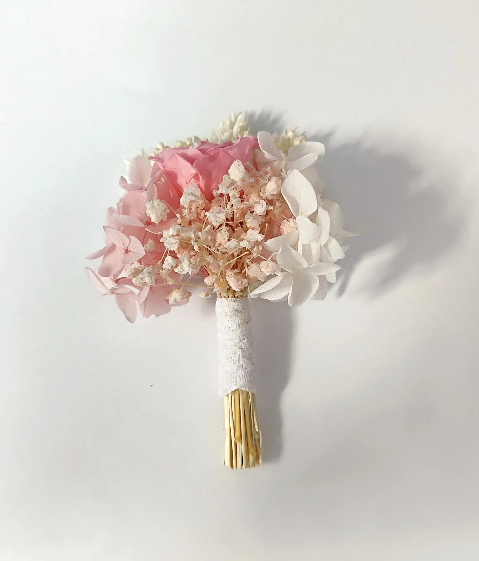 Botonier novio: rosa preservada rosa con hortensia blanca y tallo de encaje