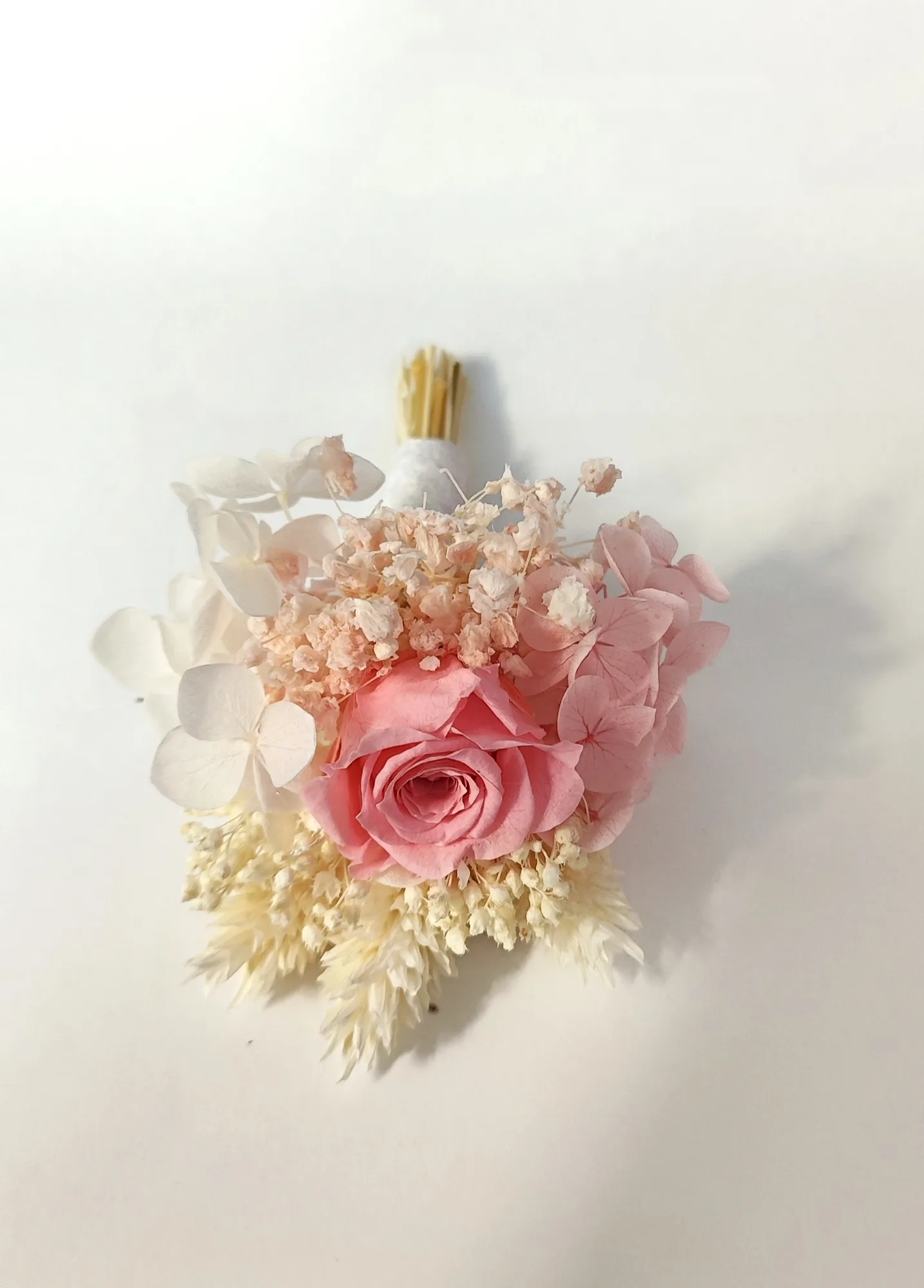 Detalle de la rosa preservada rosa y la hortensia del botonier de novio