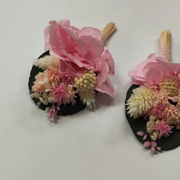 Boutonniere novio: hortensia rosa empolvado con siemprevivas crema sobre hoja de eucalipto