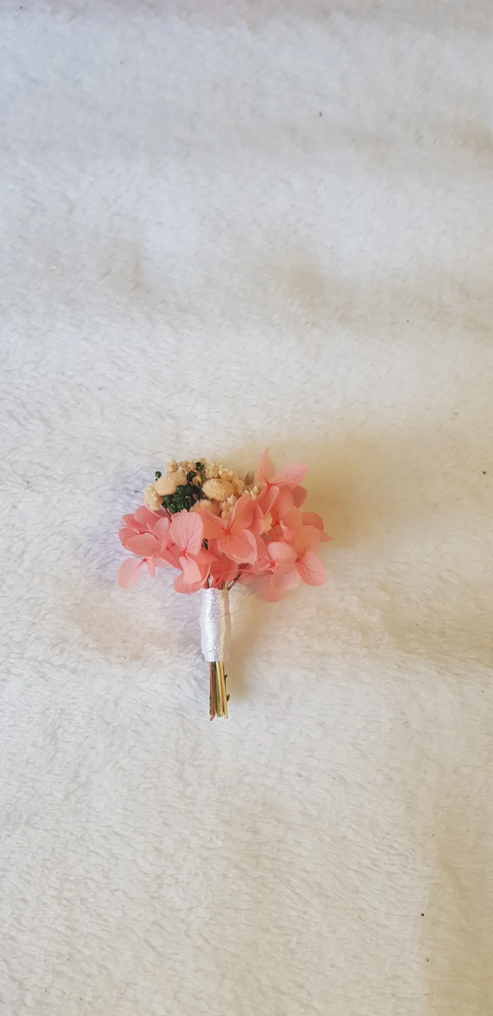 Prendido rosa coral con hortensia preservada y paniculata crema