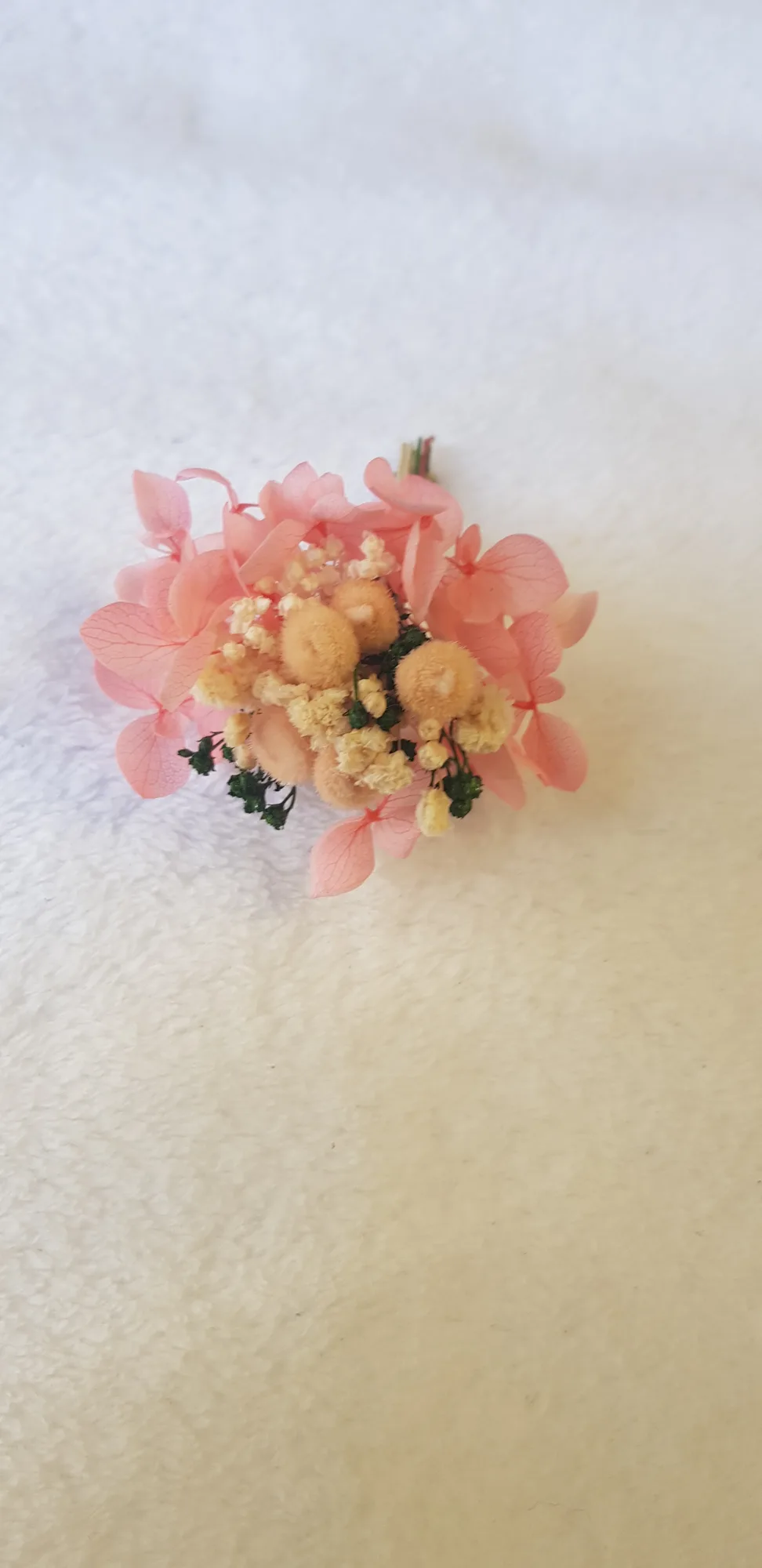 Detalle de la hortensia rosa coral y las flores crema del prendido