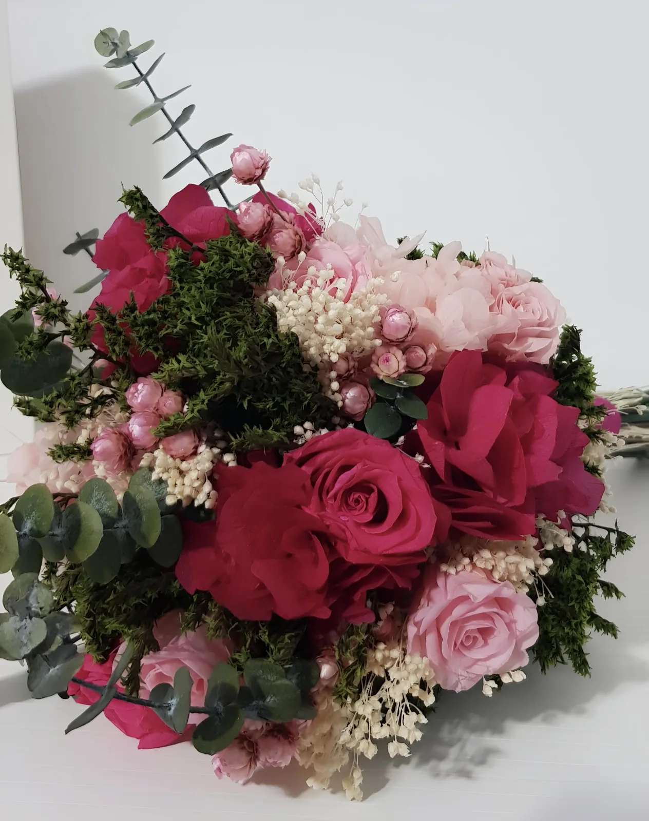 Detalle de las rosas fucsia y rosa claro, hortensias y pequeñas siemprevivas rosas