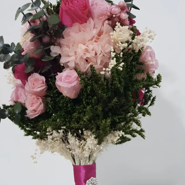 Ramo de novia con hortensias y rosas preservadas en rosa claro y fucsia, con cinta de raso fucsia y broche plateado