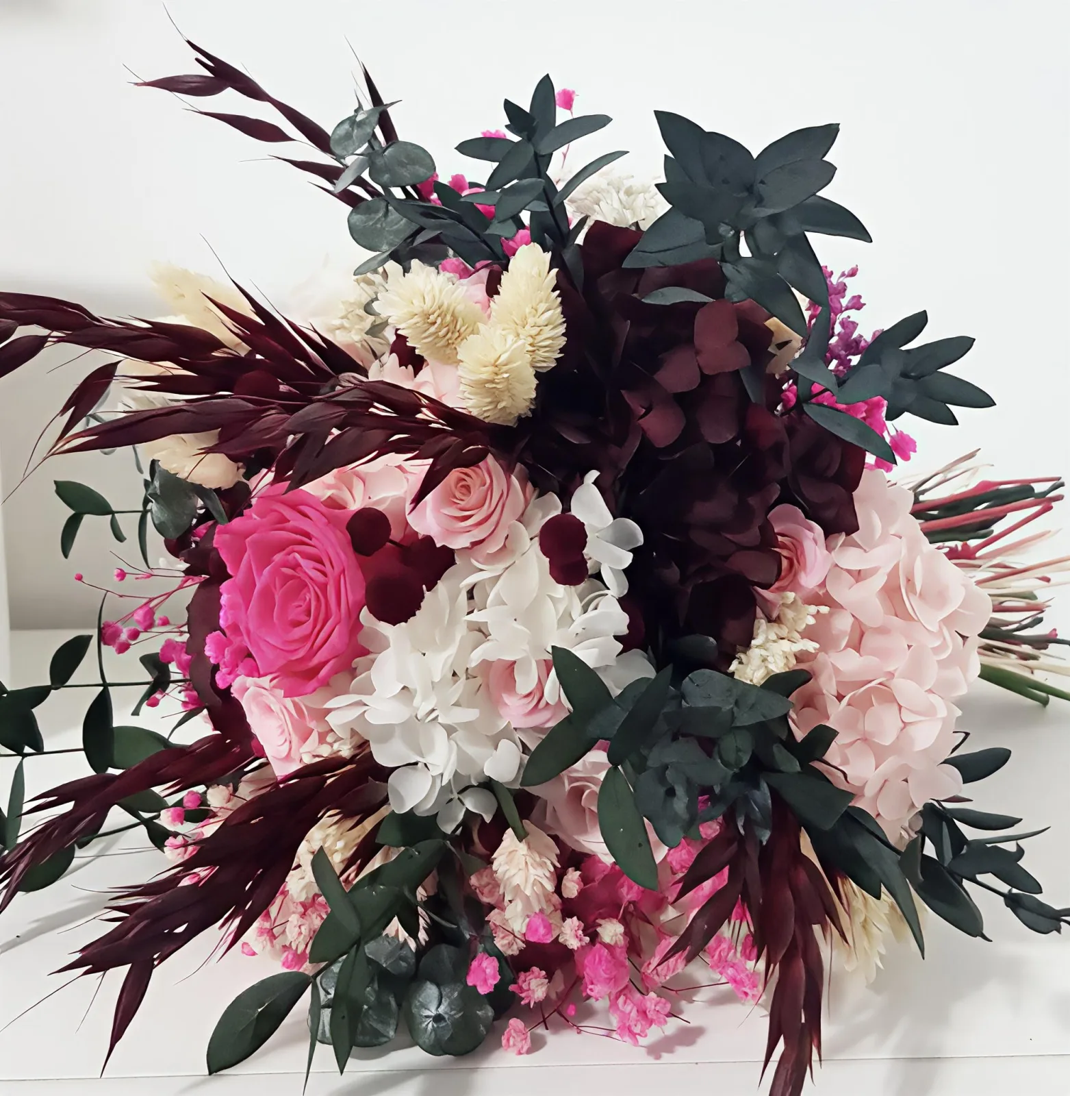 Ramo de novia de flores preservadas en fucsia, rosa claro, blanco y burdeos con eucalipto