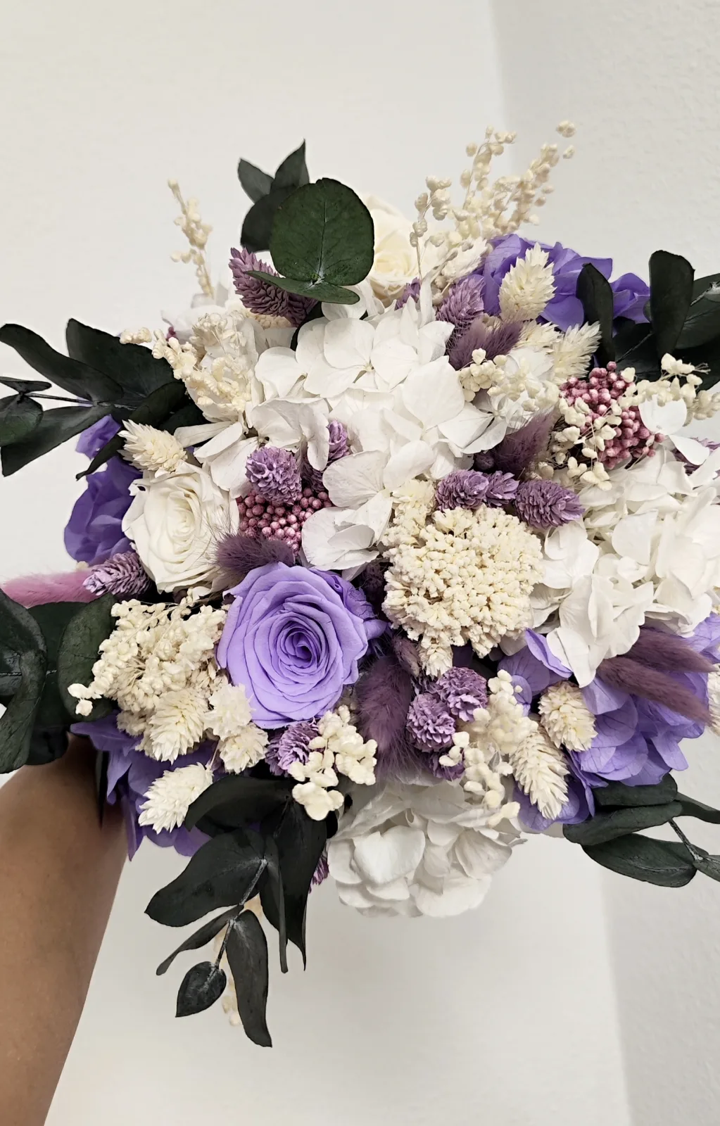 Detalle de las rosas lila y blancas, hortensias, espigas malva, flor de arroz y lagurus del ramo preservado
