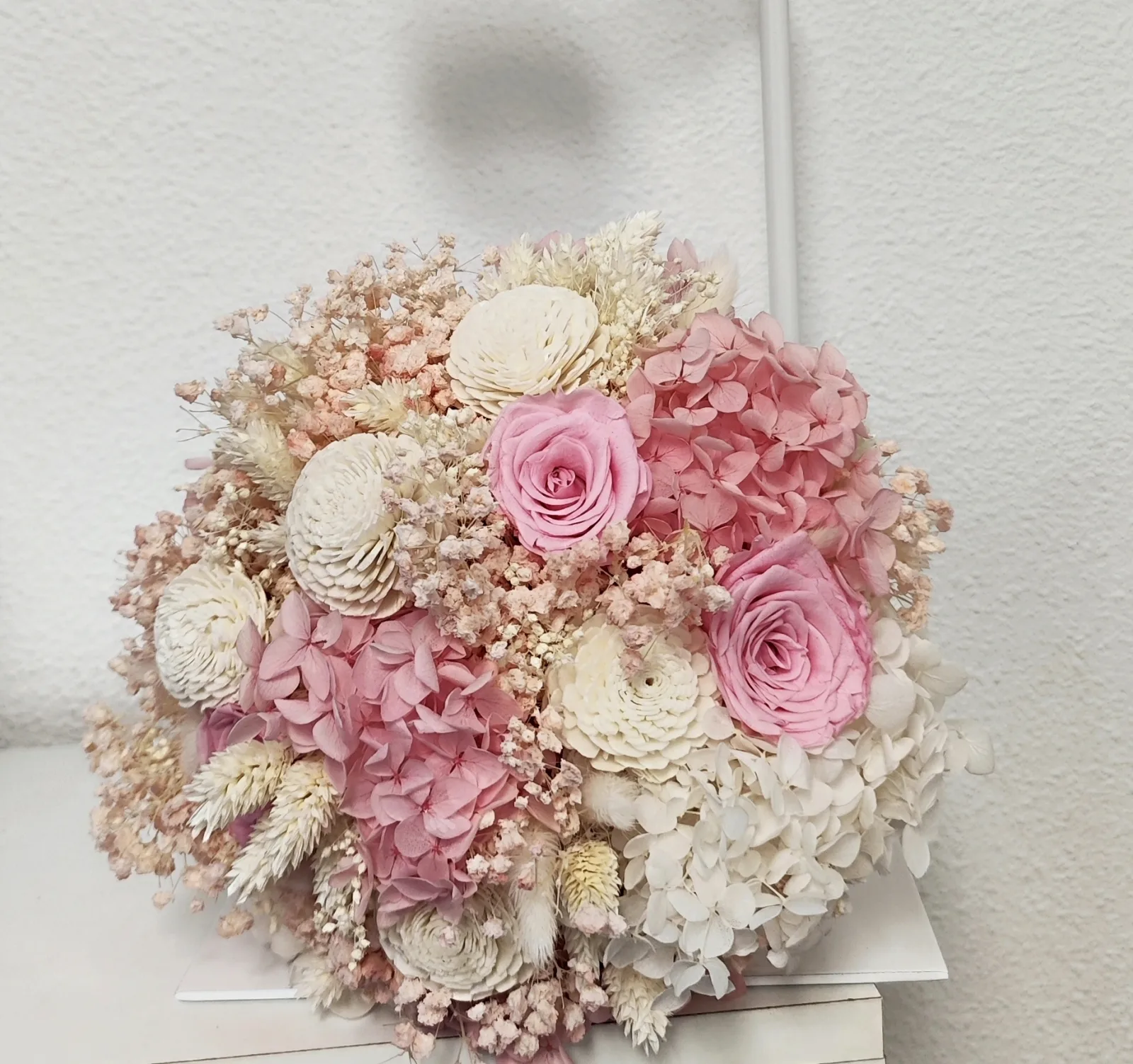 Vista desde arriba del ramo con hortensias blancas y rosa claro, rosas rosa palo y paniculata rosa suave