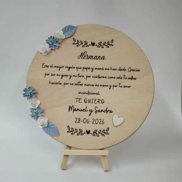 placa de madera redonda para hermana con dedicatoria grabada, flores decorativas azules y blancas y corazón de madera